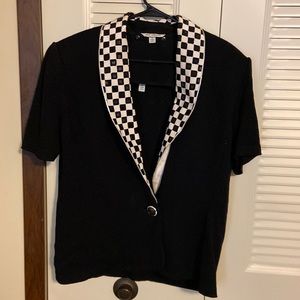 A St. John’s , black sweater with detachable black and white collar .